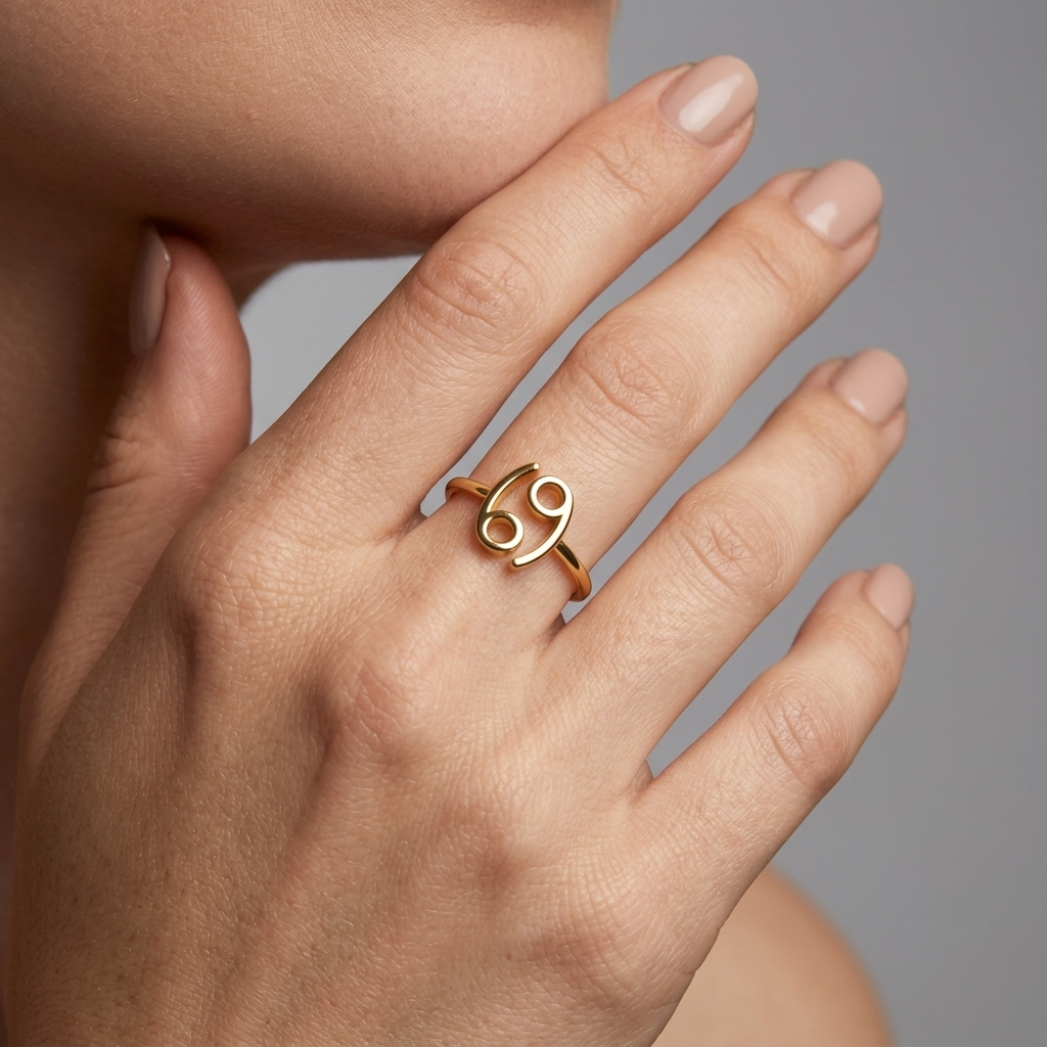 Close-up detail of Cancer symbol engraving on 14K gold ring