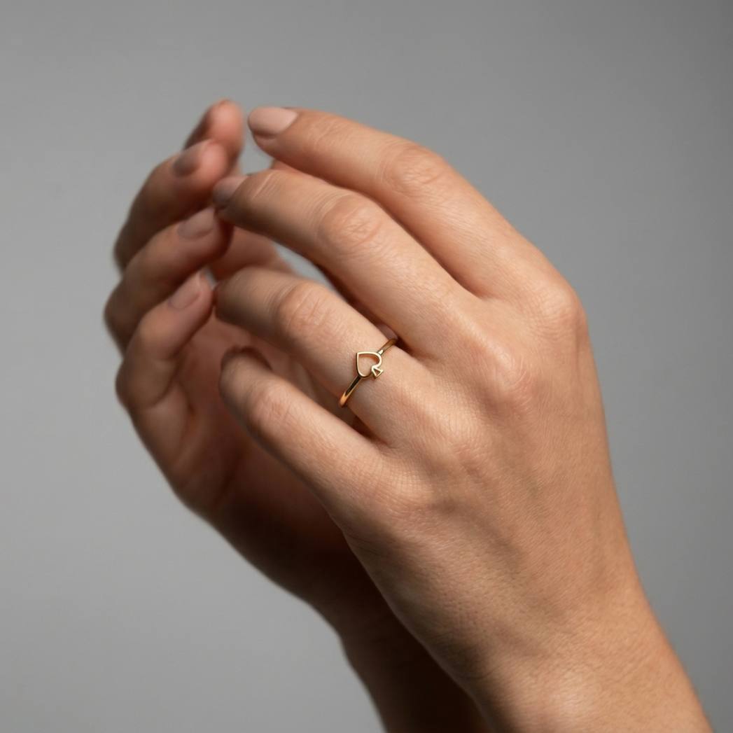 Queen of Spades solid gold ring, close-up front view , model photo lifestyle blurred