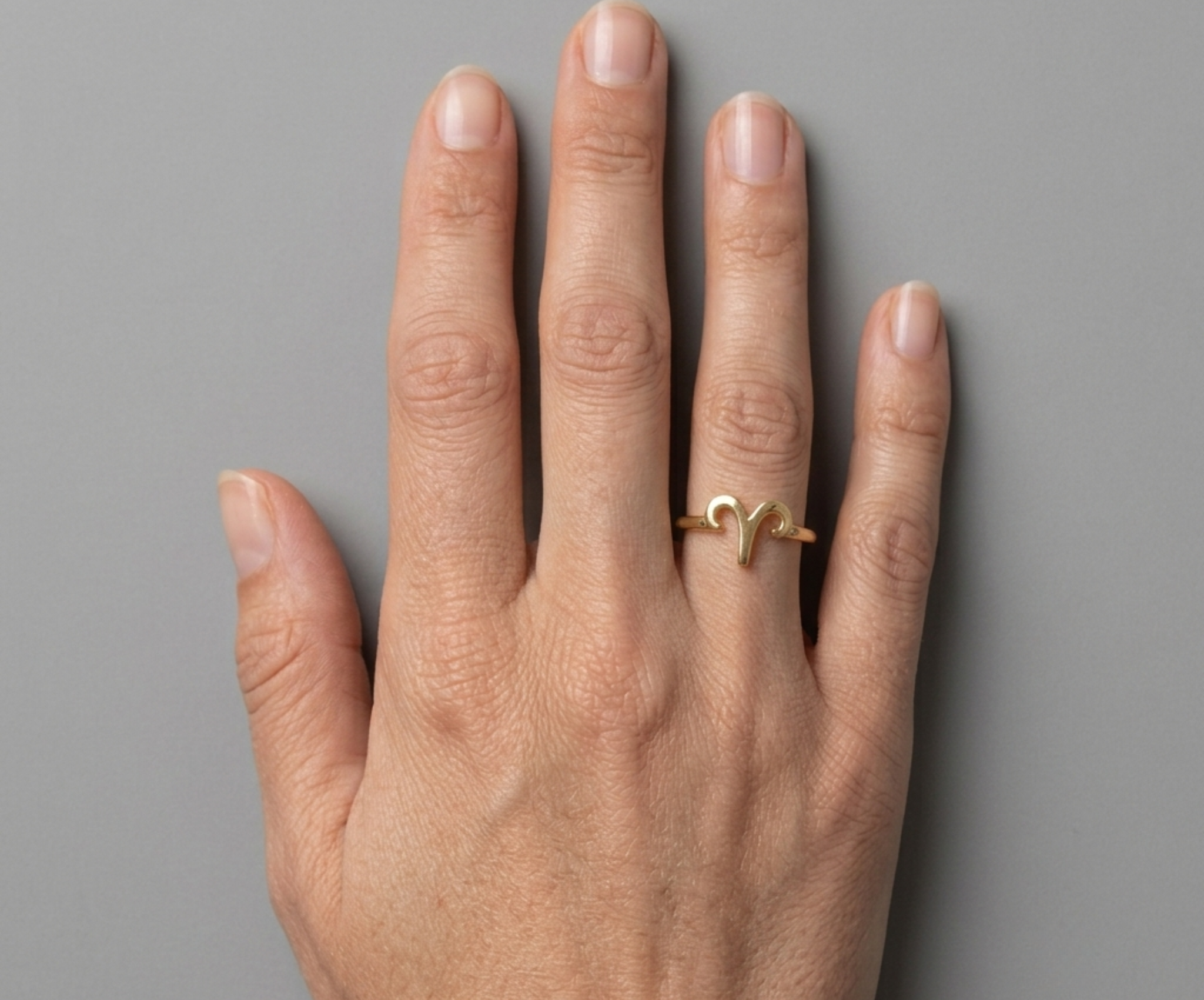 Starsky XII Aries gold ring on grey studio background