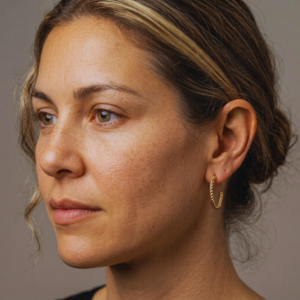 Close-up of intertwined rope knot detail on gold hoop earring