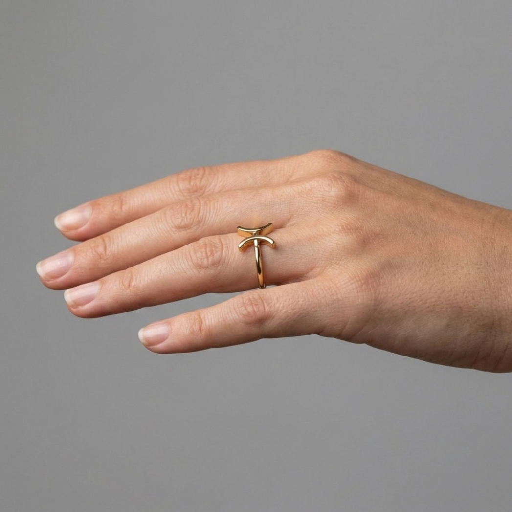Pisces gold ring worn by model, lifestyle shot with natural hand pose
