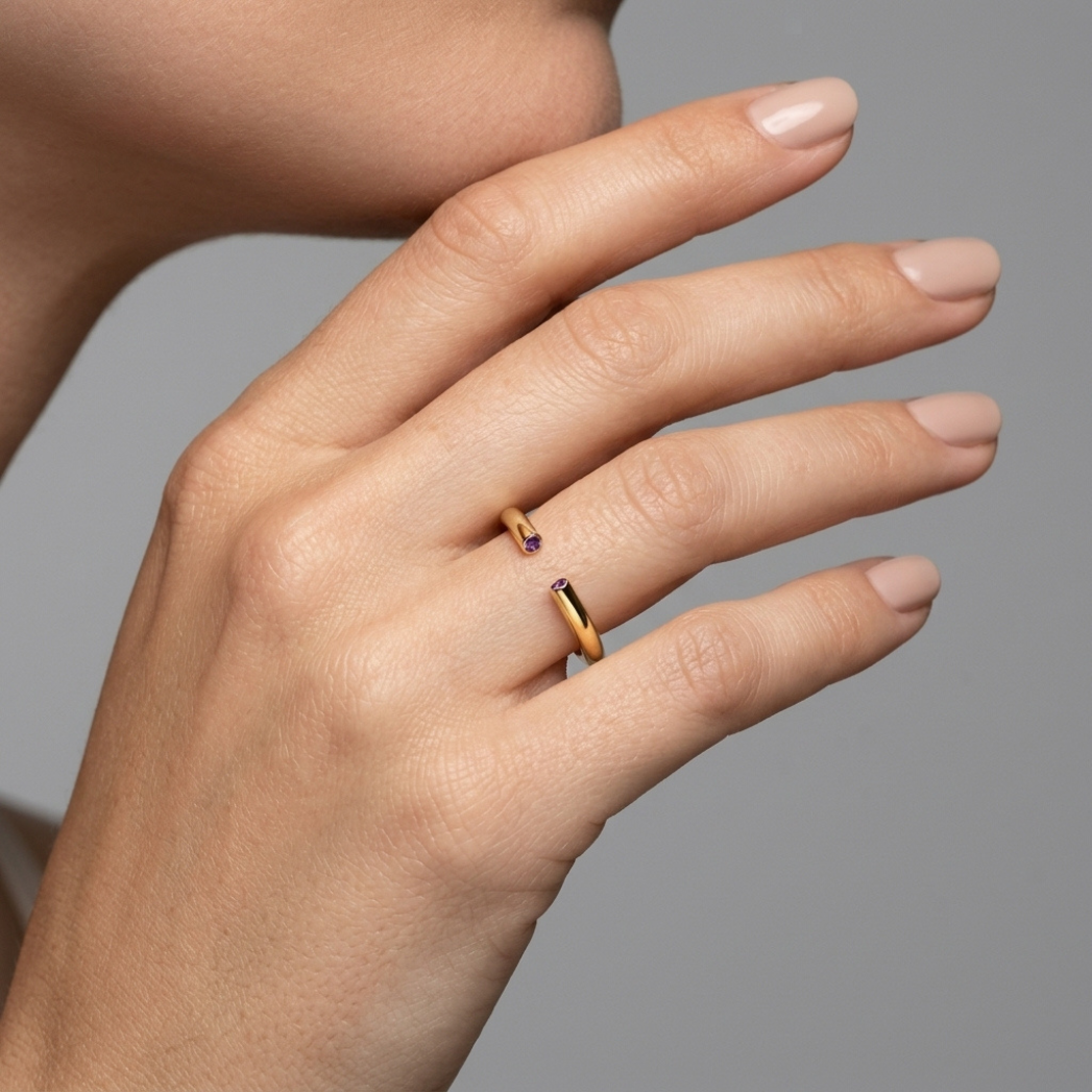 Close-up of deep violet amethyst set in 14-karat gold open band ring