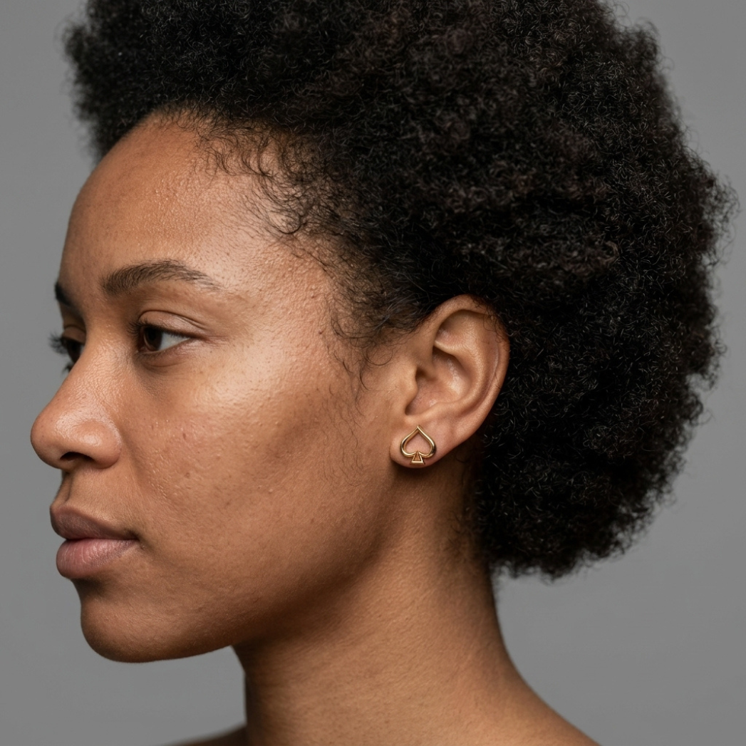 Close-up of a woman styling the Ace of Spade Hoops, showcasing their minimalist yet bold gold aesthetic.

