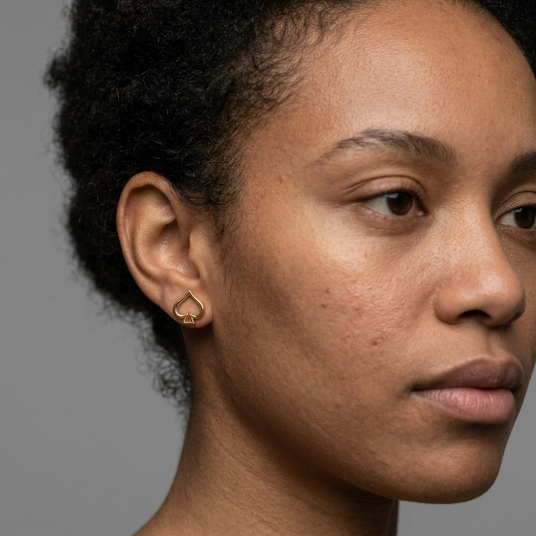 Close-up of a model styling the Ace of Spade Hoops, showcasing their minimalist yet bold gold aesthetic side view.
