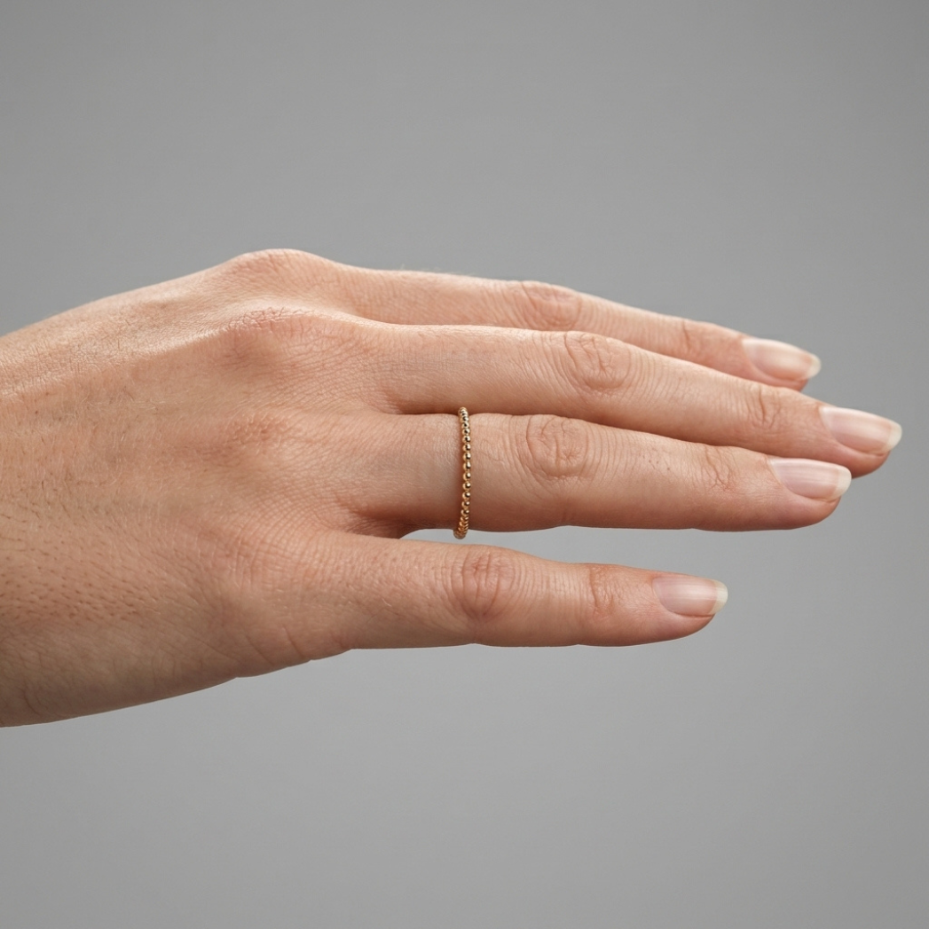 Parlé gold bead stacking ring, hand close up model side view